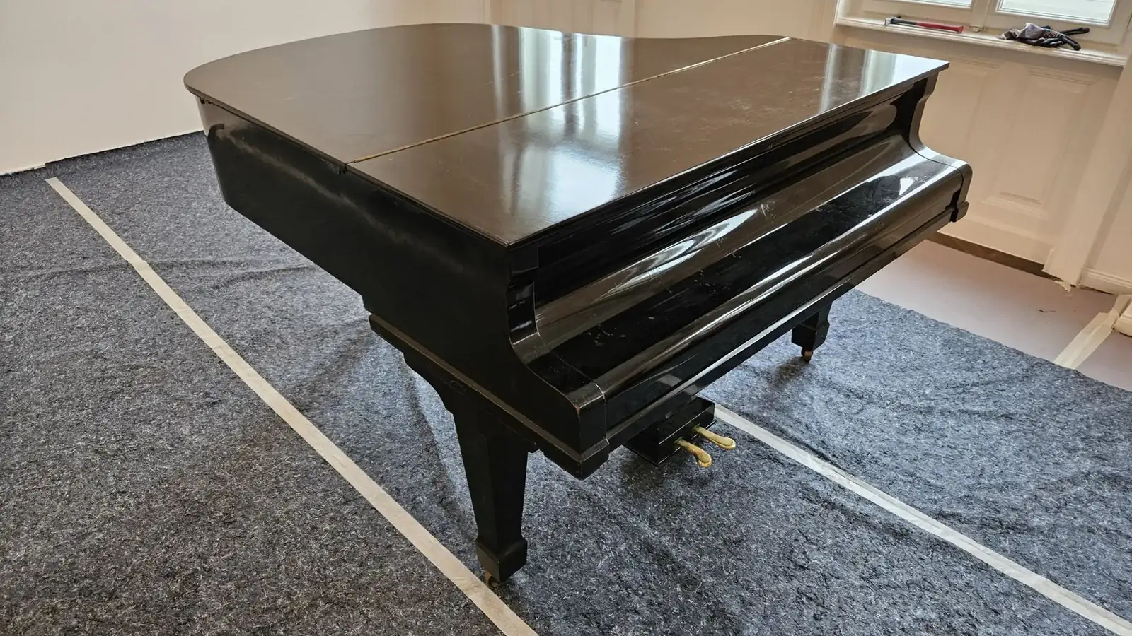 Flügel auf Bodenschutzvlies in einer leeren Wiener Wohnung