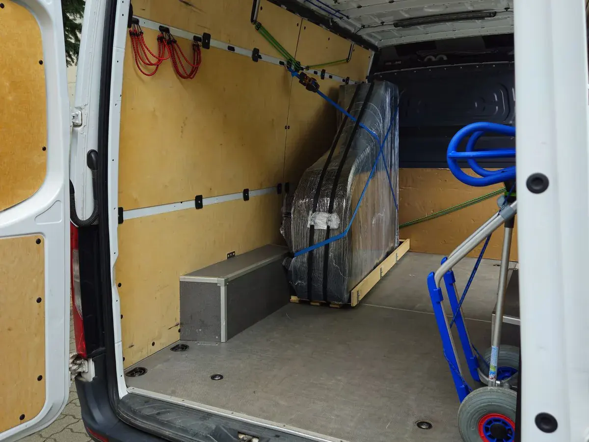 Pianino auf dem Schlitten im Transporter